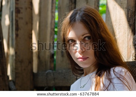 close-up of beautiful woman against a old wooden wall