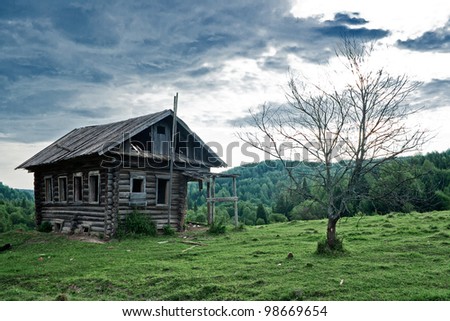 Old abandoned house and dead tree in Russian north
