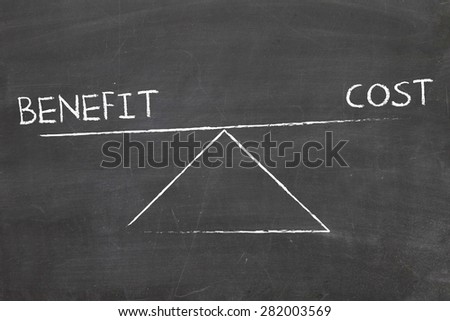 balance between benefit and cost written by hand on blackboard