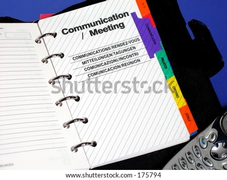 Planner opened to Communication/Meeting; cell phone on blue