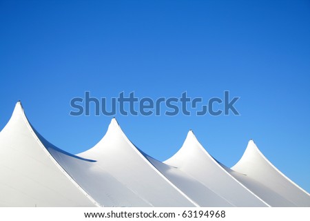 White canvas event tents against blue sky.