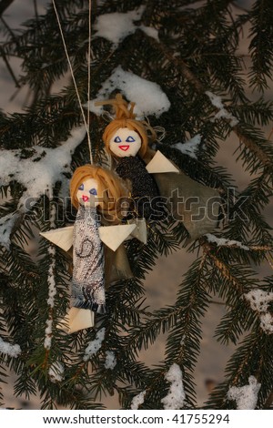 couple of victorian handmade toy angels on fir tree