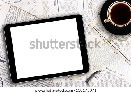 digital tablet and coffee cup on newspapers