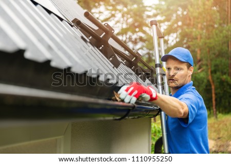 worker cleaning house gutter from leaves and dirt Сток-фото © 