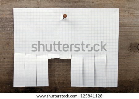 advertisement paper with cut slips hanging on nail
