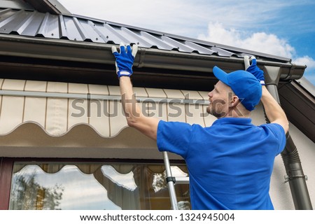 man installing house roof rain gutter system Сток-фото © 