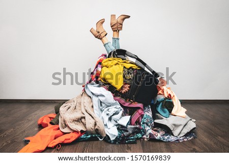 woman legs out of a pile of clothes on the floor. shopping addiction concept Сток-фото © 