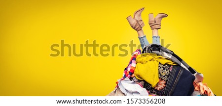 woman legs out of clothes pile on yellow background with copy space ストックフォト © 
