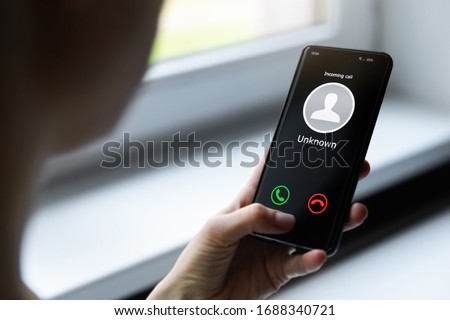 woman holding mobile phone with incoming call from unknown caller