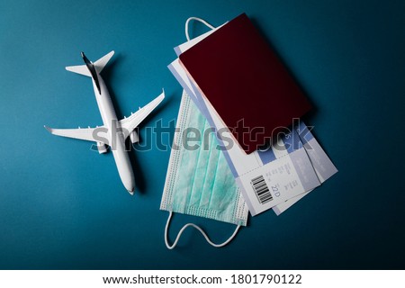 travel during the covid-19 pandemic. airplane model with face mask and travel documents