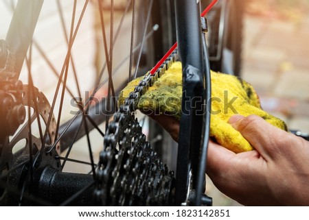 Image, Stock Photo Technician oiling bike chain in workshop