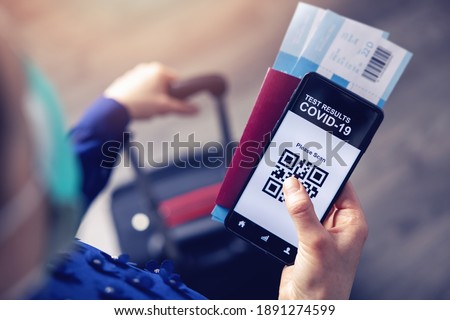 person in airport using mobile app in phone to show covid-19 test results for travel