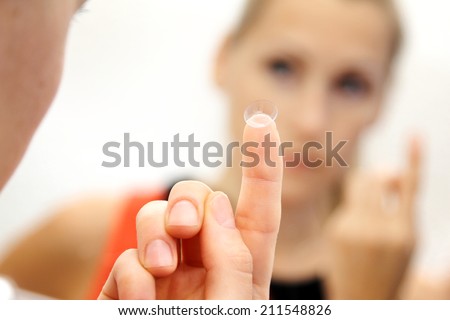 woman with contact lens on her finger