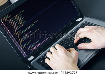 programmer occupation - writing programming code on laptop