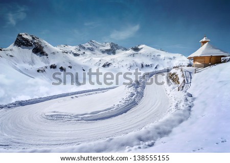 Empty snow covered mountain road in winter landscape