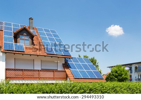 House with garden and solar panels on the roof