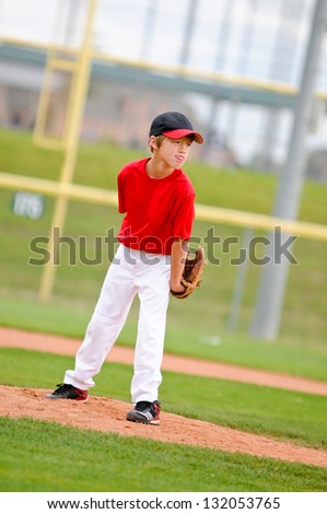 Baseball pitcher on the mound wearing a red jersey.