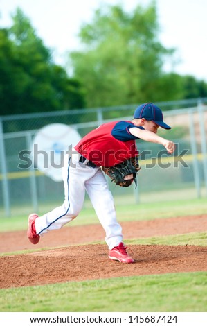 Little league baseball boy pitching during a game.