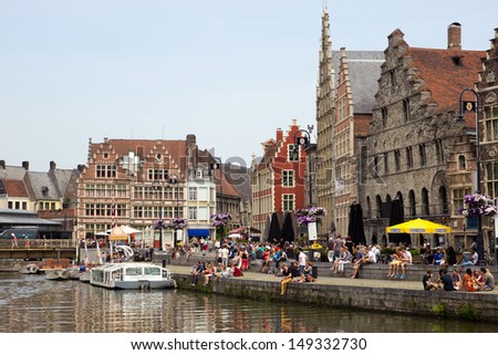 GHENT - JUN 18: Tourists and students in the historical center of Gent with it\'s gabled houses along the canal in Gent June 18, 2013 in Ghent, Belgium