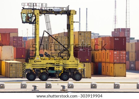 ANTWERP, BELGIUM - JUL 9, 2013: Straddle carrier moving shipping containers in the Port of Antwerp.