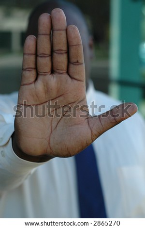 Hand gesture of an African American man showing the command to stop.