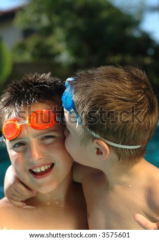 Little brother kissing his older brother in the pool