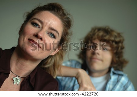 Parenting concept portrait of an attractive middle aged mother and her teenage son