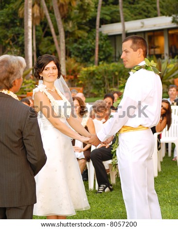 Outdoor destination wedding in Hawaii; happy couple holding hands