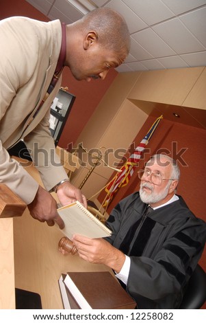 Young lawyer showing a document to the judge during trial