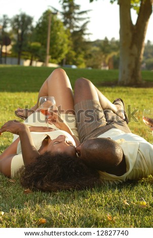 Carefree, relaxed couple enjoying the sunshine with a mellow drink of wine