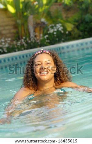 Healthy young woman swimming in a backyard pool