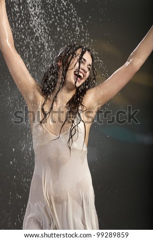 happy young woman in the rain in a wet white dress