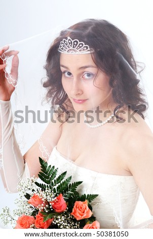 The young bride in a white dress and a diadem in hair, roses