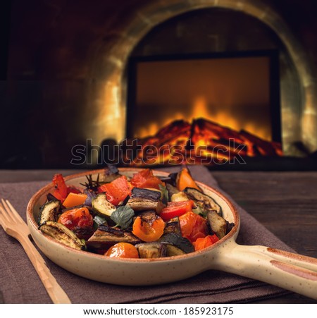 Grilled vegetables on serving pan and fireplace