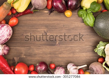 Frame of various vegetables over wooden table with copy space