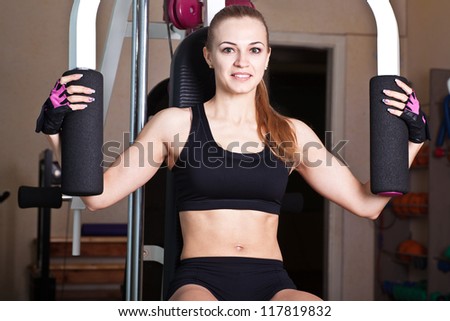 sportswoman do her exercises in training apparatus