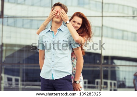 woman covering man\'s eyes hands. portrait couple at outdoor