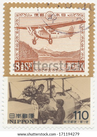 JAPAN - CIRCA  1995: A stamp printed in Japan shows First Osaka-Tokyo airmail flight and workers loading freight onto airplane, Postal History Series, circa 1995