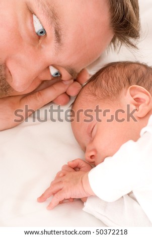 beautiful baby sleeps next to his father