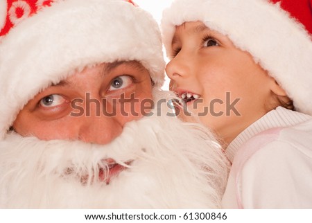 boy whispers to Santa on a white background