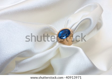 Golden napkin ring with white satin napkin