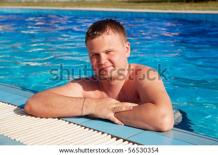 Young sexy  man posing in the swimming pool