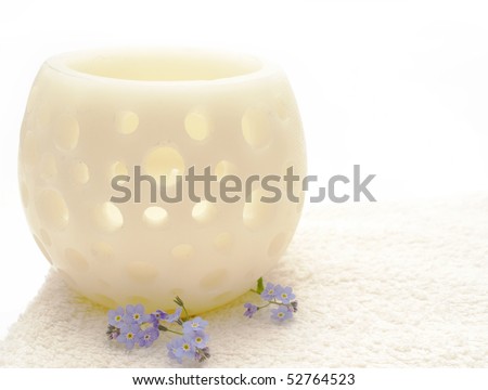 white towel with white candla  and   blue forget-me-not on white  background