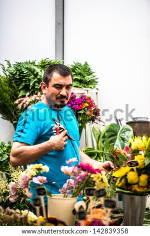 STUTTGART, GERMANY - June 15, 2013:  A Florist finishing a beautiful  flower arrangement for a client in an open booth located in the central shopping street on June 15, 2013 in Stuttgart, Germany.