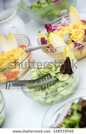 salad buffet - various salads in bowls: potato, cucumber, green salad and dressing