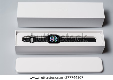 OSTFILDERN, GERMANY - MAY 13, 2015: Unboxing the new Apple Watch: Outer box with inner plastic case carrying the actual device, a black 42mm Apple Watch Sport displaying the apps screen. The Apple