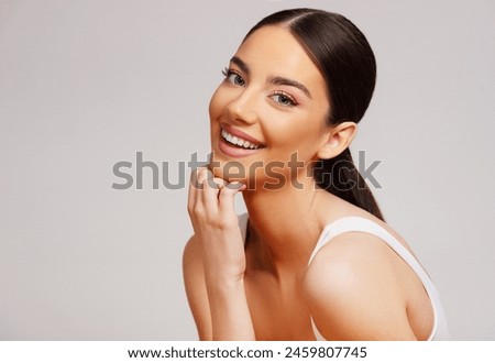 Image, Stock Photo A pretty girl in a hat is sitting on the sofa near a Christmas tree, dressed up for the holiday, the child is smiling and rejoicing at the gift