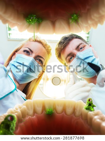 Two dentists examining teeth, view from the inside of the mouth