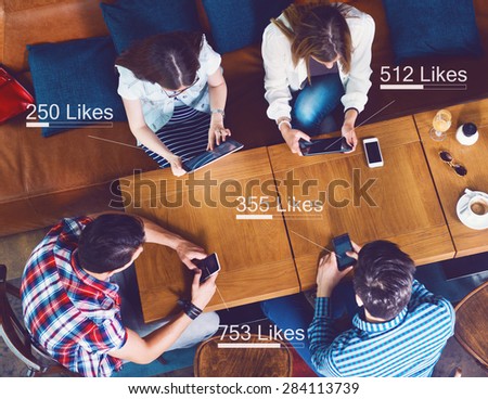 Group of young people sitting at a cafe, counting likes, top view