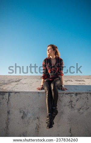 Outdoor portrait of sitting beautiful hipster girl thinking and dreaming